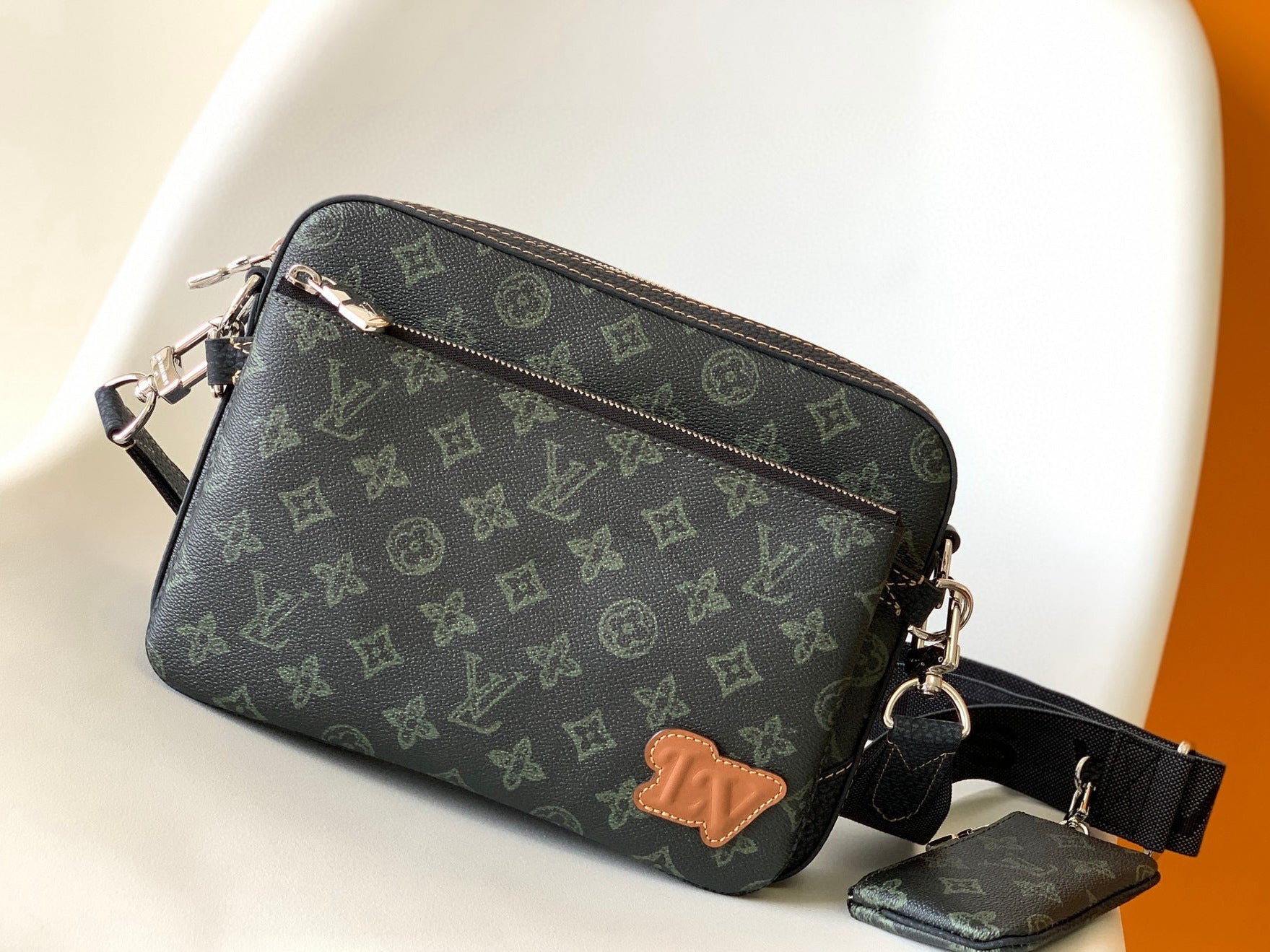 Designer handbag with monogram pattern on a white surface