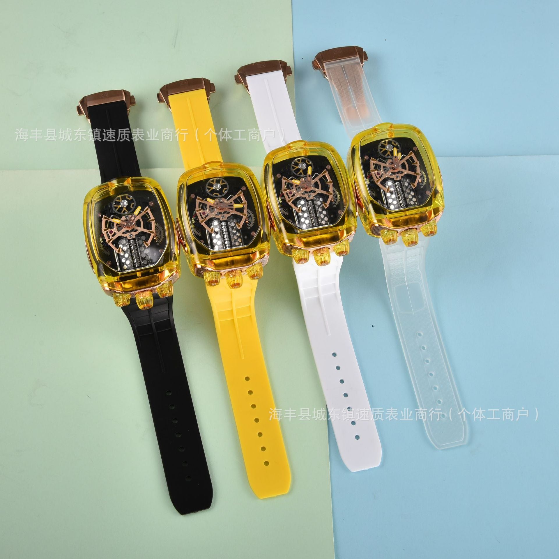 Four wristwatches with different colored straps on a two-tone background