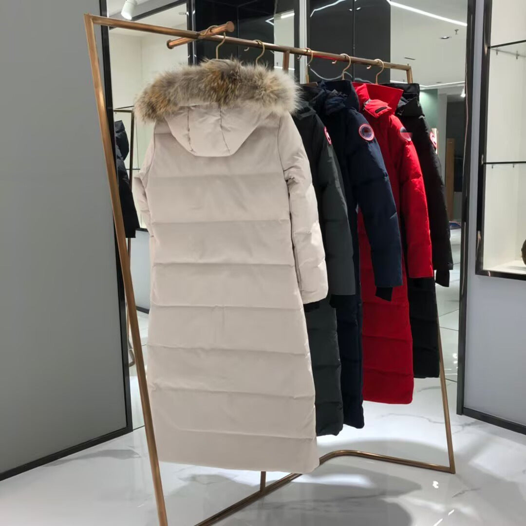 Beige puffer jacket with fur hood on a clothing rack in a store setting.