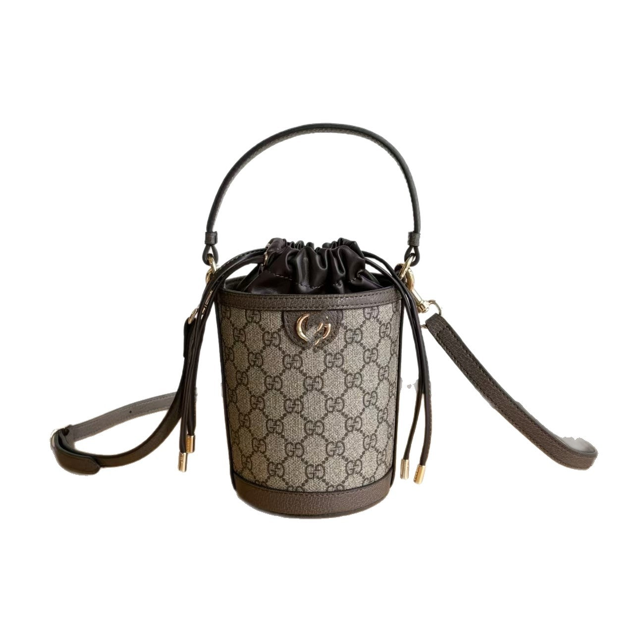 A Gucci bucket bag in the brand's signature GG Supreme canvas, featuring a brown leather top handle, a detachable shoulder strap, and a drawstring closure with gold-tone hardware.