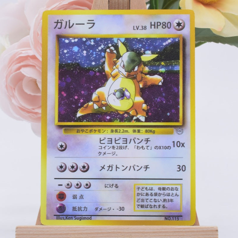 A Japanese Pokémon trading card featuring the character Garurura, displayed on a small wooden stand against a soft pink floral background.