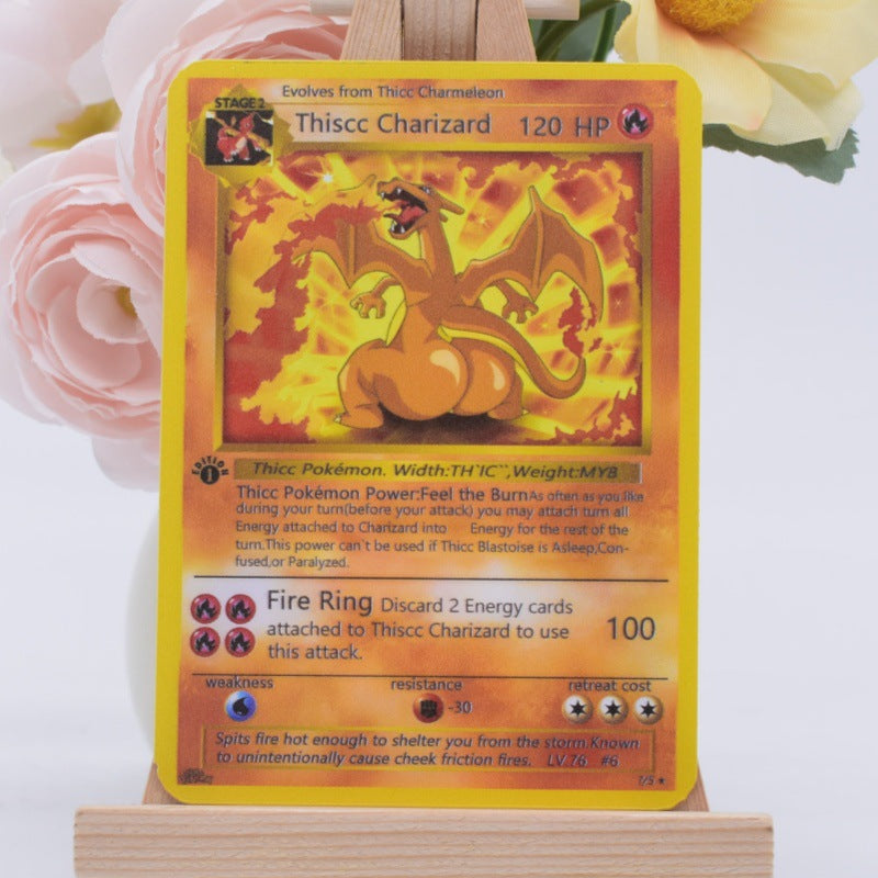 A Pokémon trading card featuring Thicc Charizard, displayed upright on a small wooden easel with soft pink and yellow flowers blurred in the background.