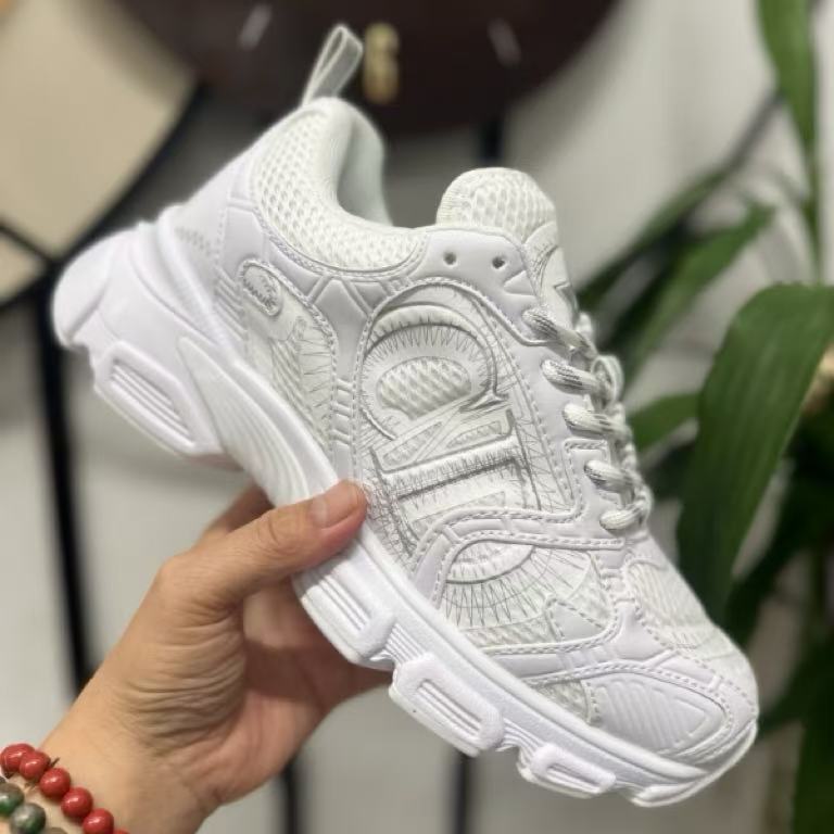 White sneaker held in a hand with a blurred background