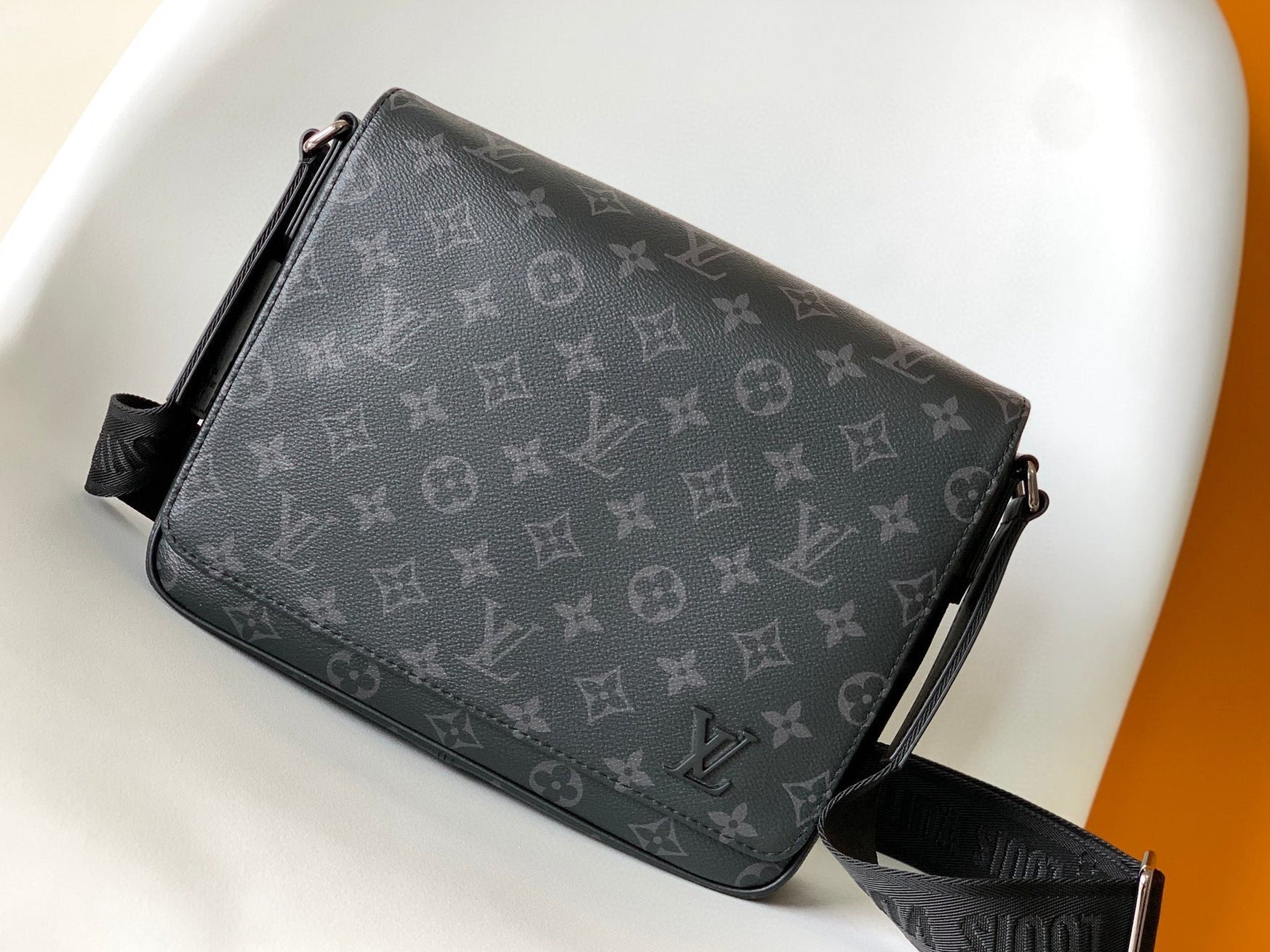Designer bag with monogram pattern on a white surface
