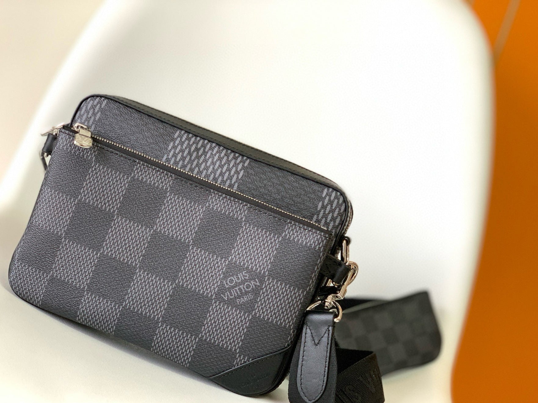 Gray checkered handbag with a strap on a white background