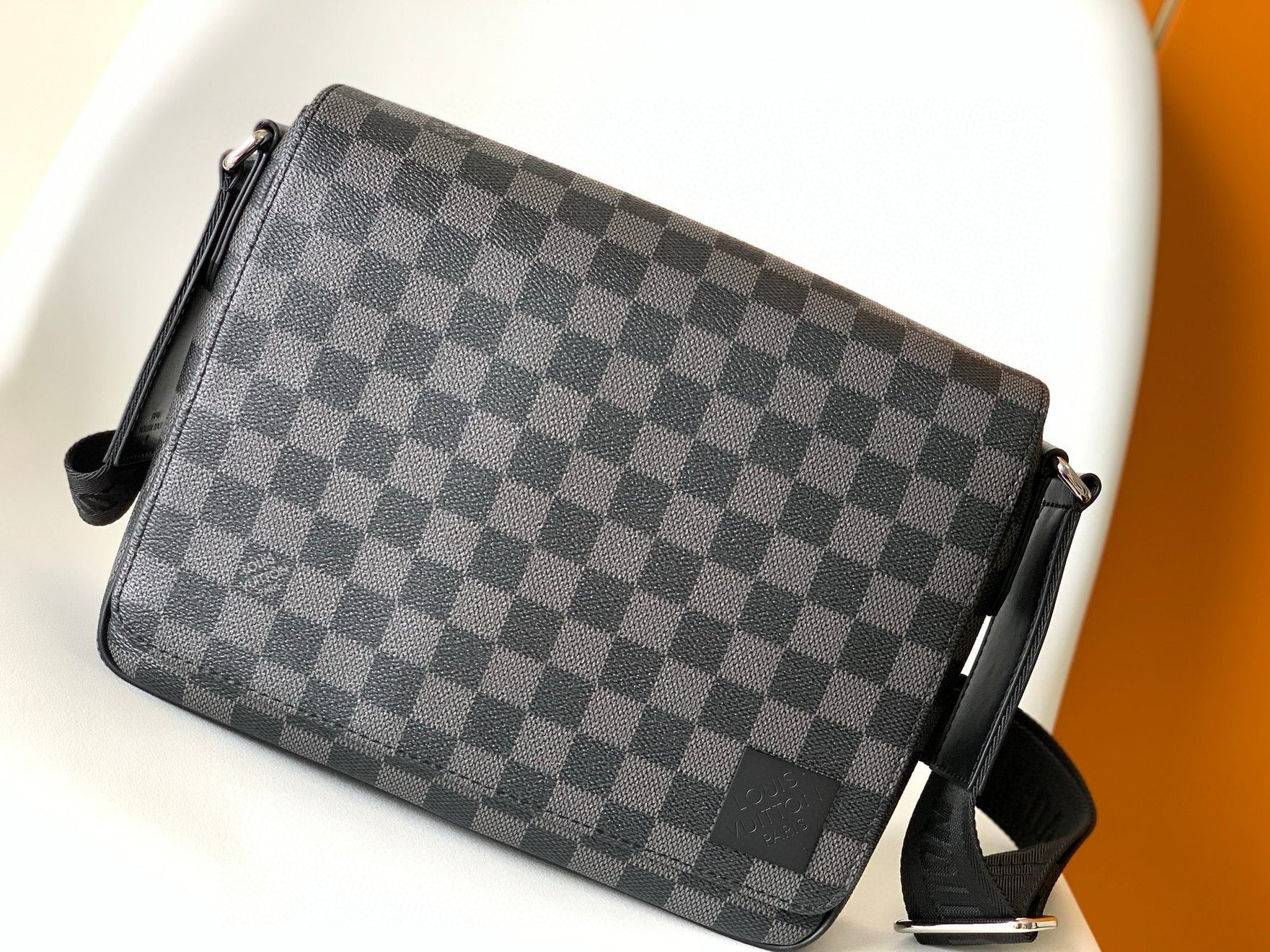 Gray checkered handbag with a visible brand logo on a white background
