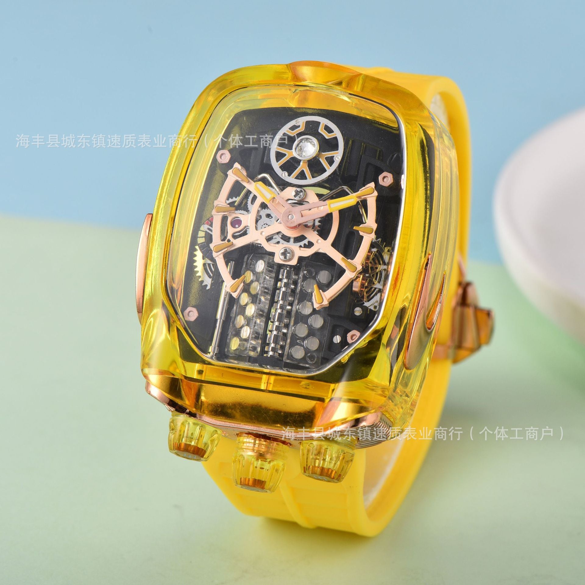 Gold wristwatch with transparent case on a light blue and green gradient background
