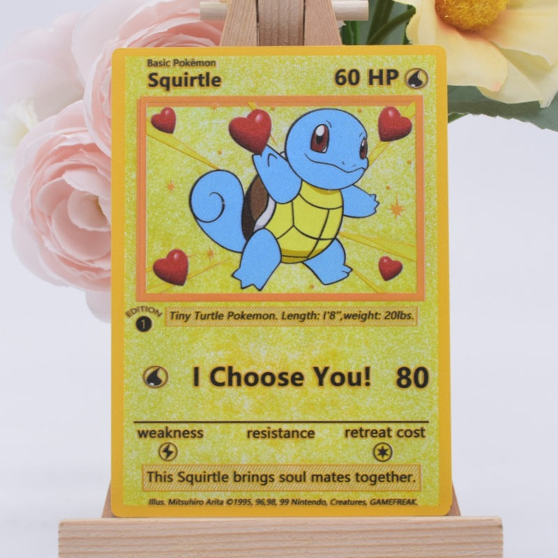 A collectible Squirtle trading card displayed upright on a small wooden stand, with soft pink and yellow flowers blurred in the background.