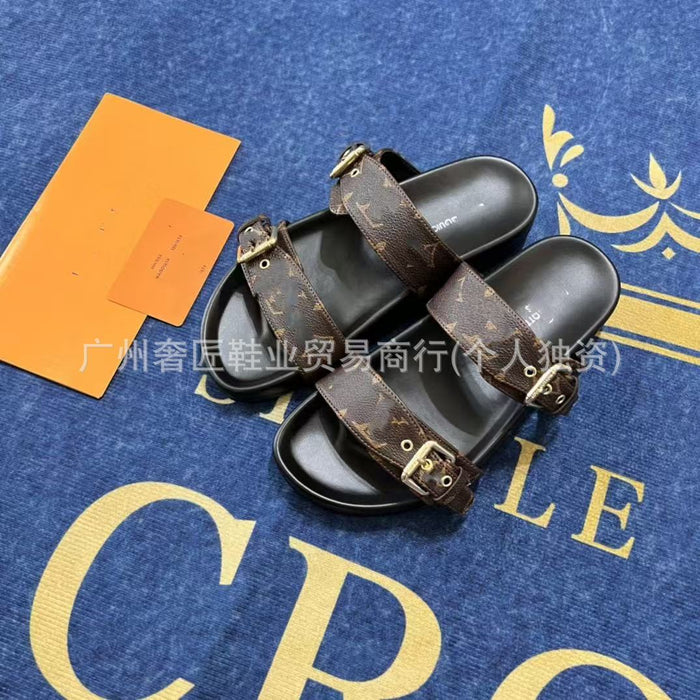 Black sandals with brown straps on a blue surface with gold text