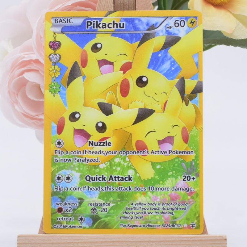 A Pikachu TCG trading card displayed upright on a small wooden stand, with soft pink flowers blurred in the background.