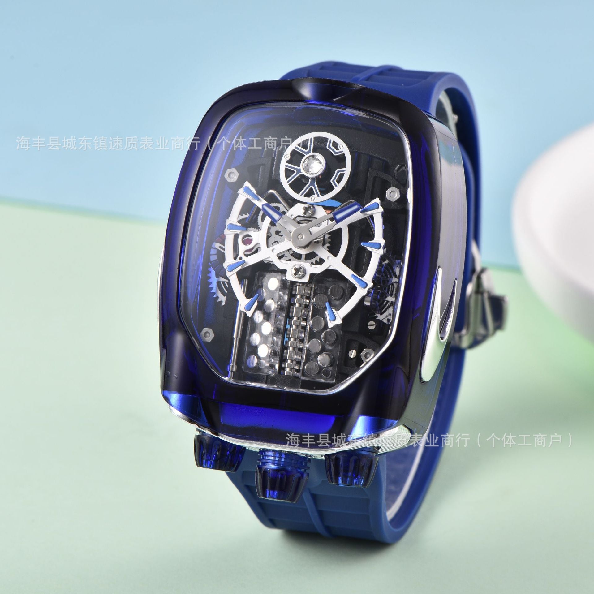 Blue mechanical watch with transparent face on a light blue background