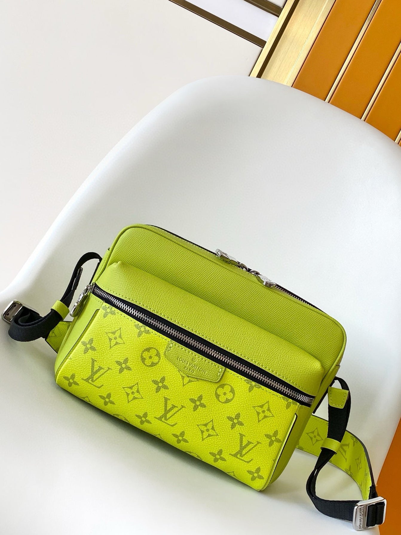 Green monogrammed bag on a white chair