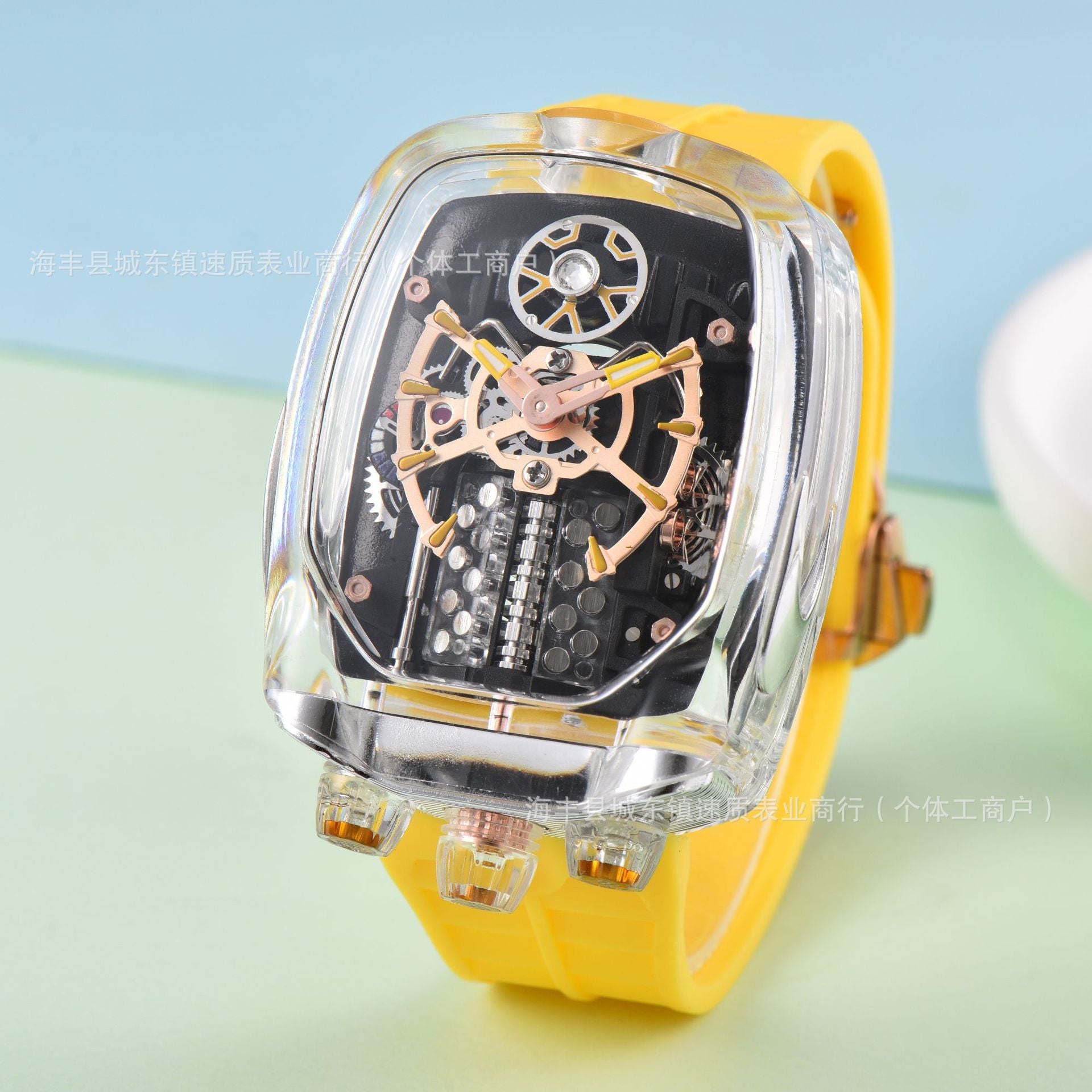 Yellow wristwatch with transparent case on a light blue and green gradient background