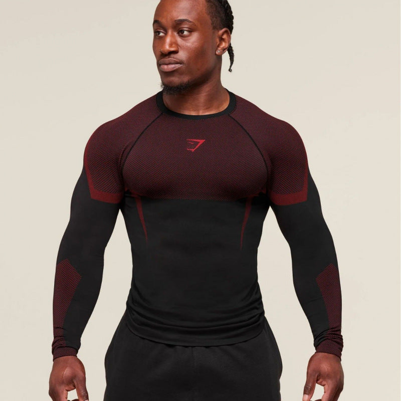 Man wearing a black and red athletic shirt with a logo on a beige background