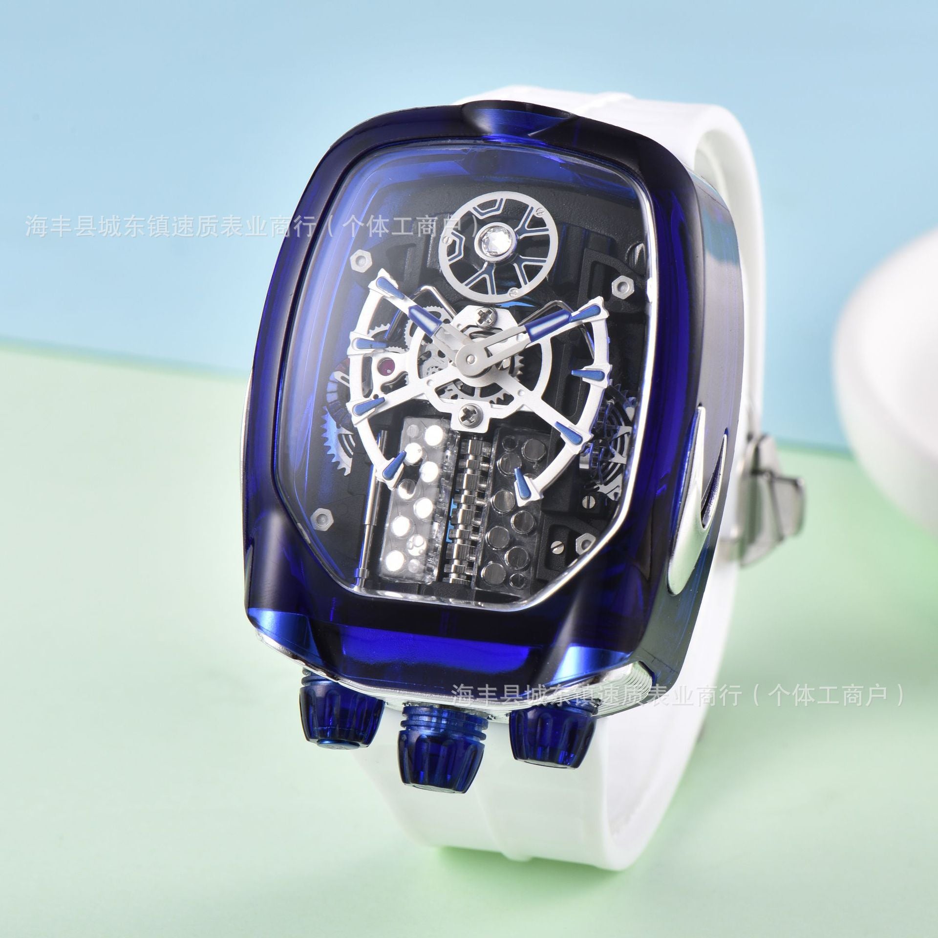 Blue and white watch with transparent face on a light blue and green gradient background