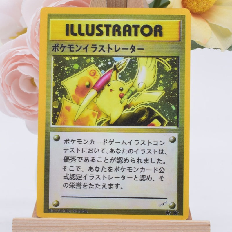 A Pokémon Illustrator trading card displayed upright on a small wooden stand, with pink and yellow flowers blurred in the background.