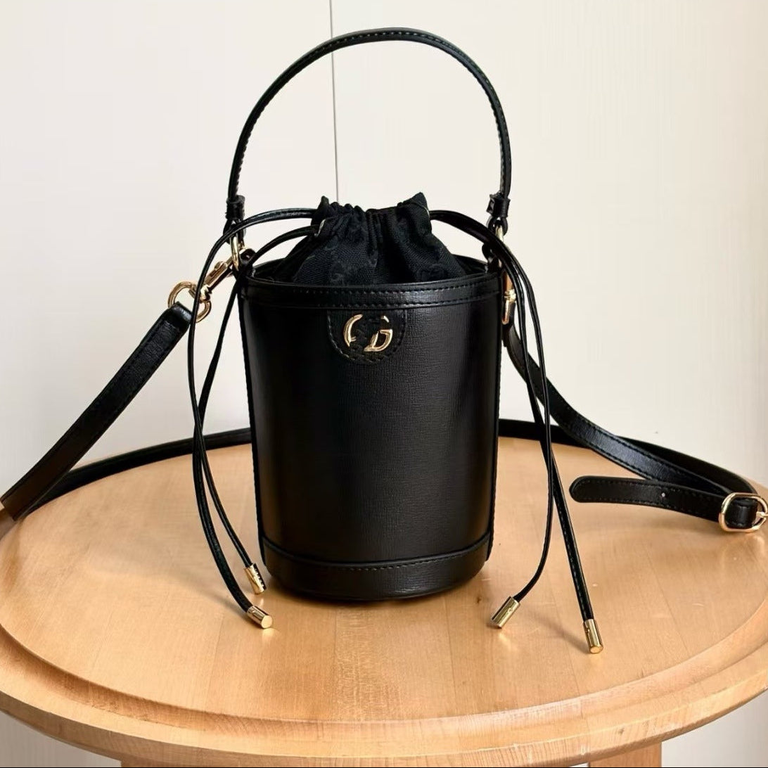 Black handbag with a brand logo on a wooden surface