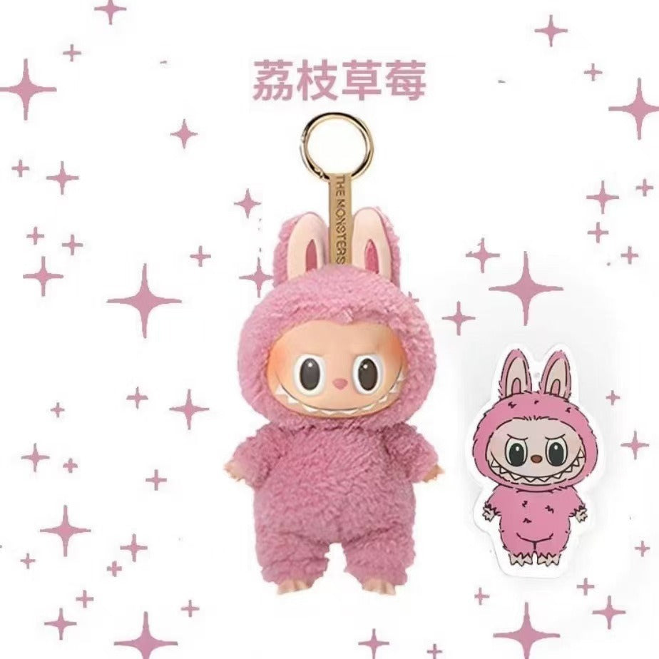 A pink plush character keychain with bunny ears and a gold key ring, shown alongside a matching flat charm sticker on a white background with pink star accents. The text at the top reads '焻钢花' in Chinese.