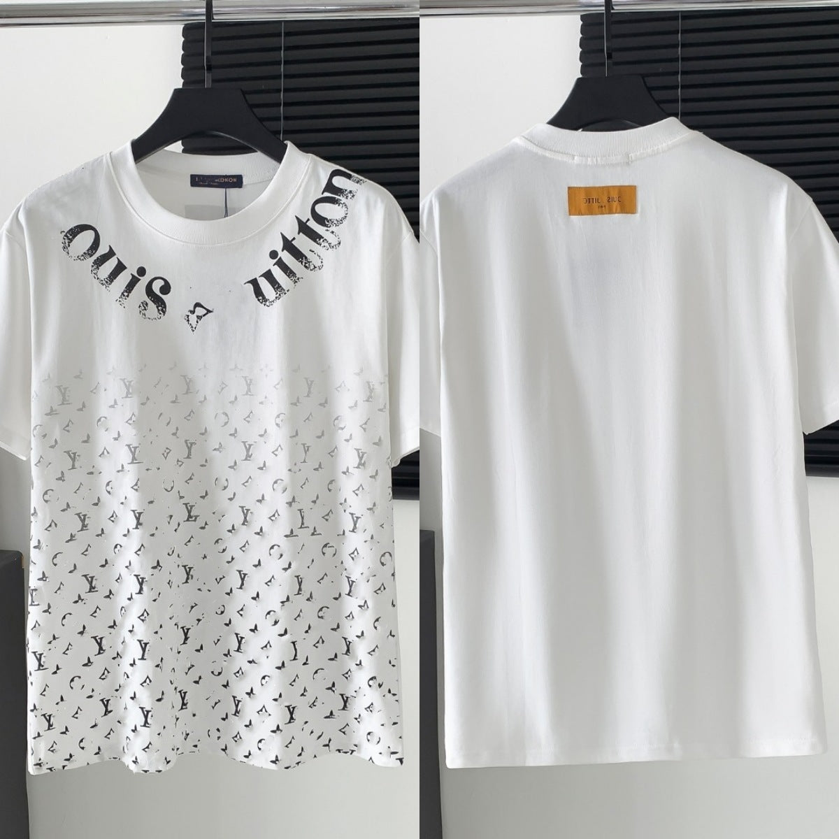 White t-shirt with black text and patterns on a hanger against a neutral background