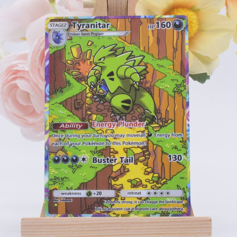 A holographic Pokémon trading card featuring the character Tyranitar, displayed on a small wooden stand with soft pink and yellow flowers in the background.