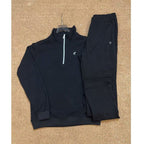 Black tracksuit laid out on a textured surface