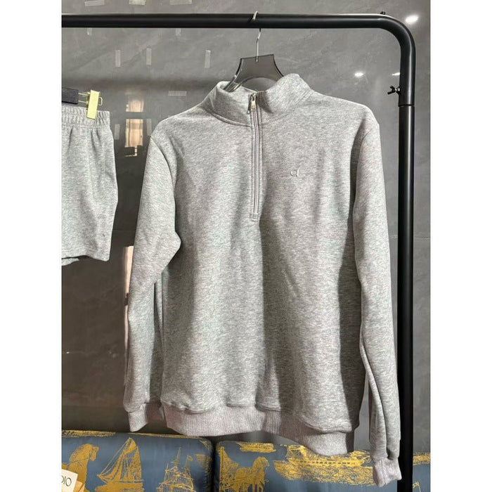 Gray zip-up sweatshirt on a hanger against a dark background