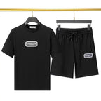 Black t-shirt and shorts set with logo on a hanger against a neutral background