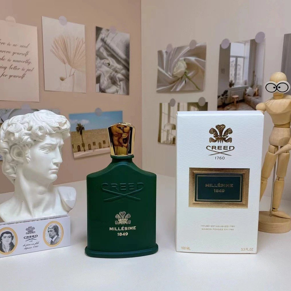 Creed perfume bottle and packaging on a surface with decorative items in the background
