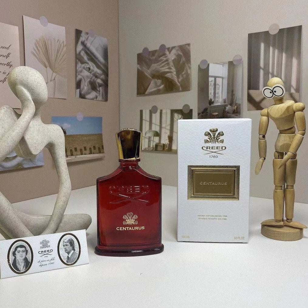 Creed Centaurs perfume bottle and packaging on a table with decorative items.