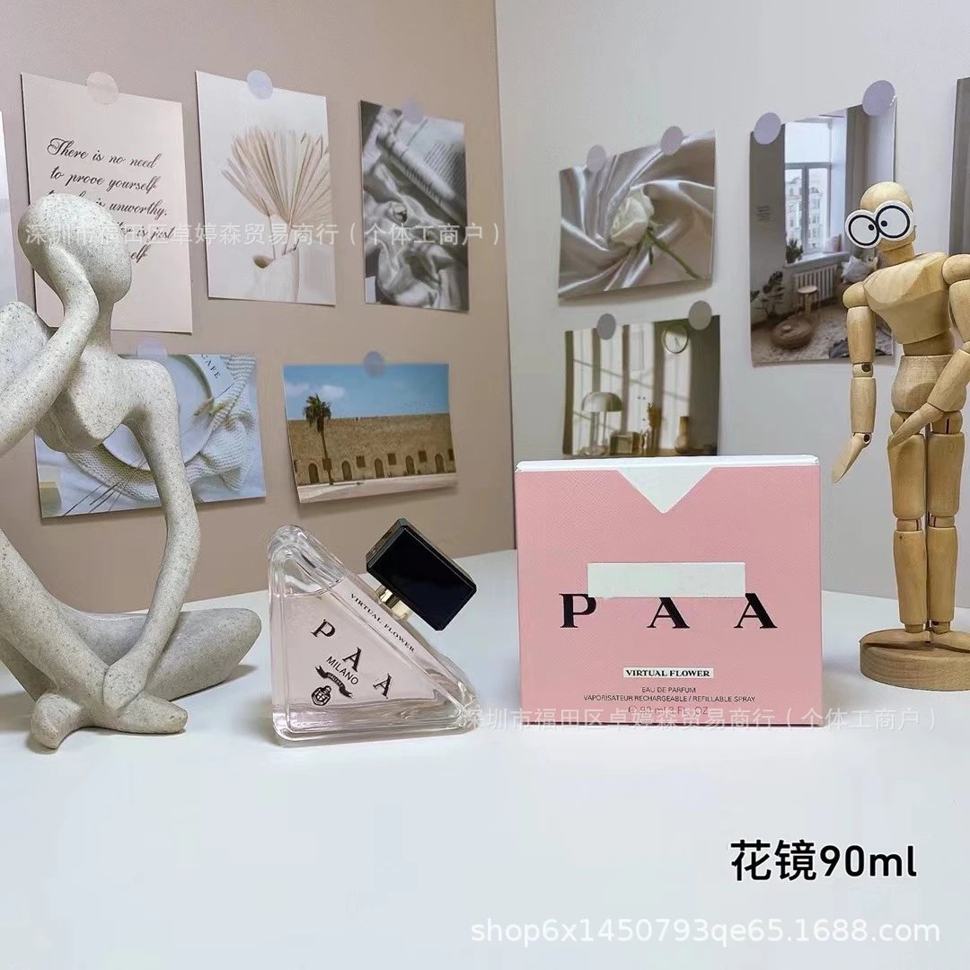 PAA perfume bottle and packaging on a table with decorative items in the background