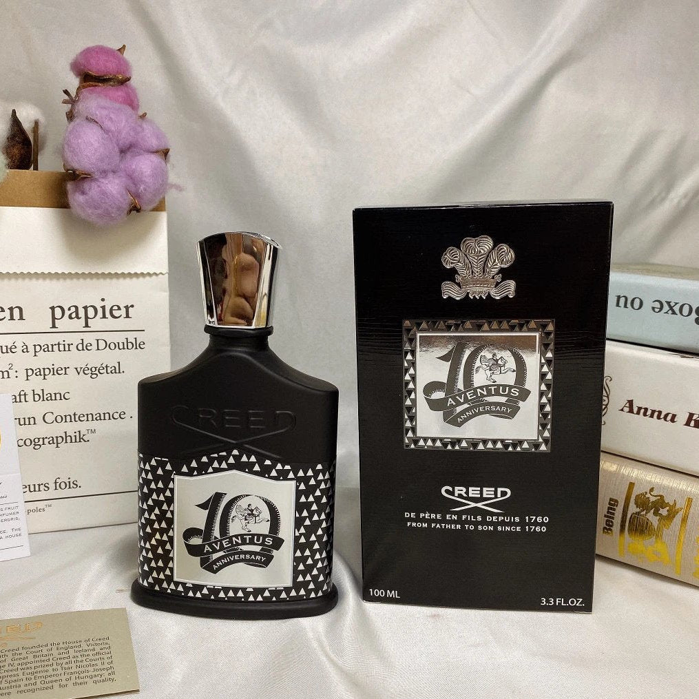 Creed Aventus perfume bottle and packaging on a white fabric background