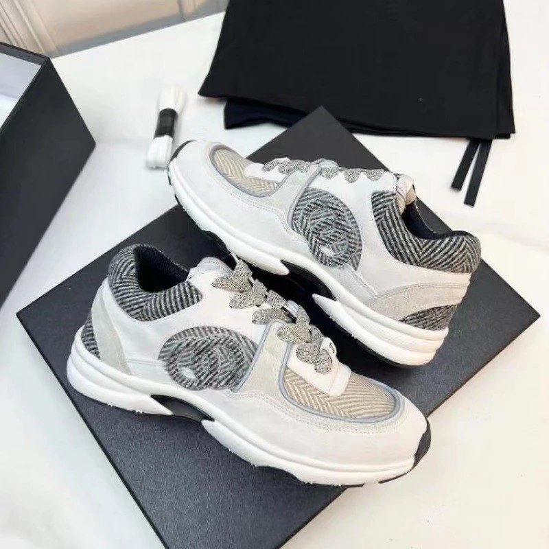 White and gray sneakers on a black box with a white background