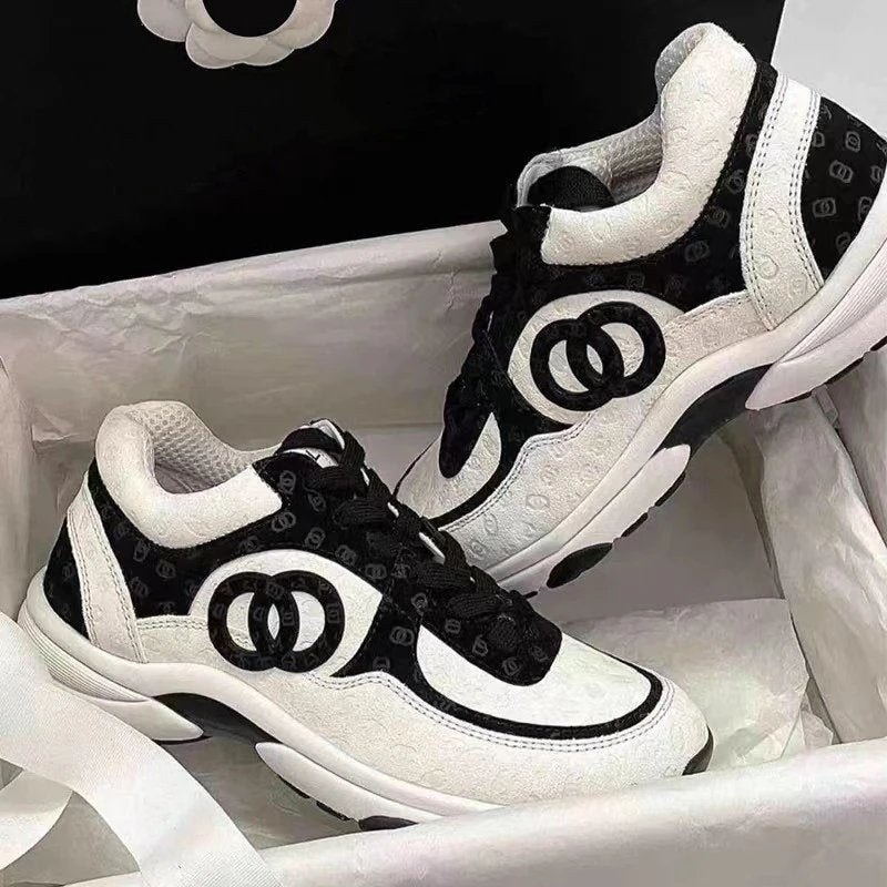 Black and white sneakers with brand logo on a white background