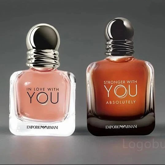 Two Emporio Armani perfume bottles on a gray background