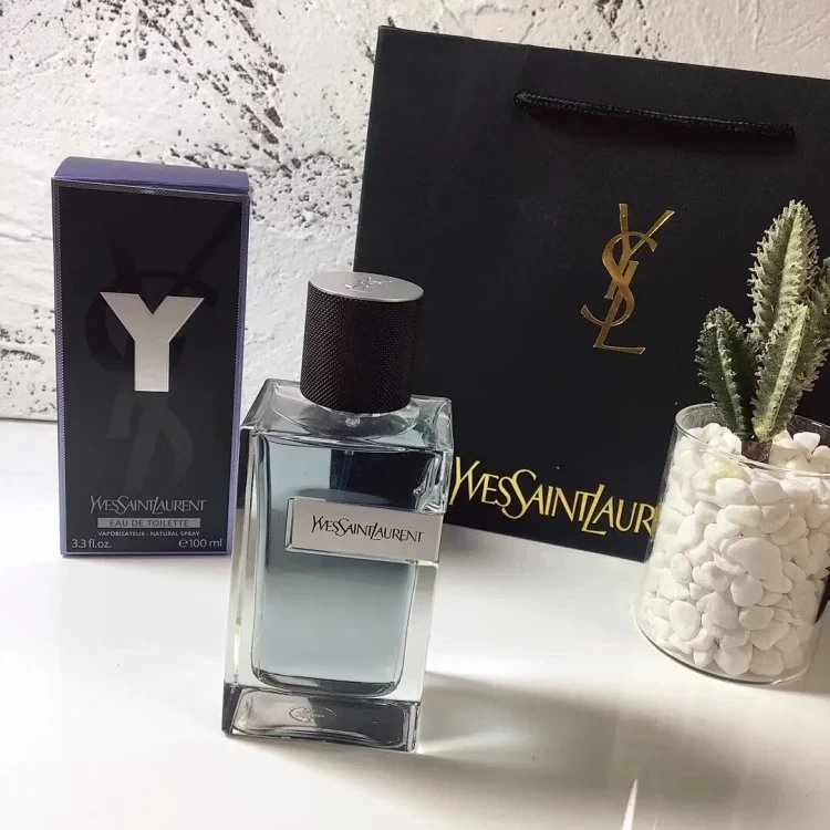 YSL perfume bottle with packaging and decorative elements on a textured surface