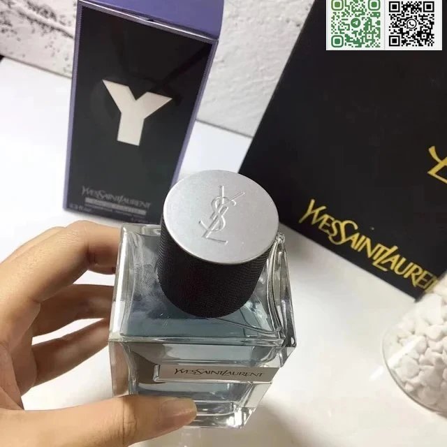 YSL perfume bottle held by a hand with YSL packaging in the background