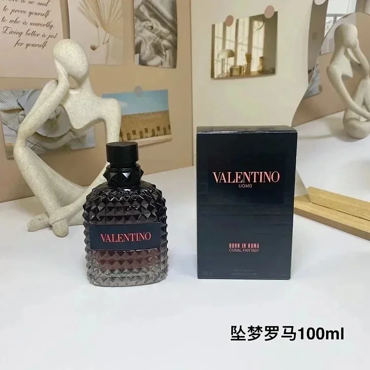 Valentino perfume bottle and packaging on a white surface with decorative elements in the background.