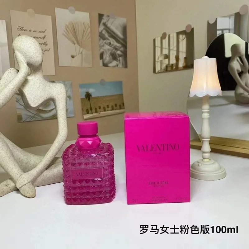 Pink perfume bottle and box on a table with decorative items in the background
