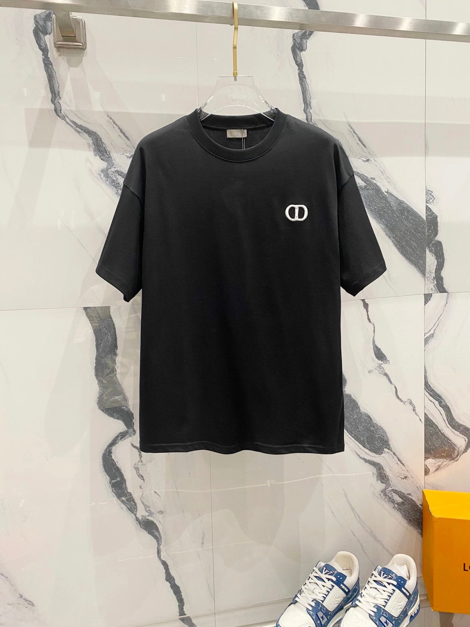 Black t-shirt with a logo on a marble surface