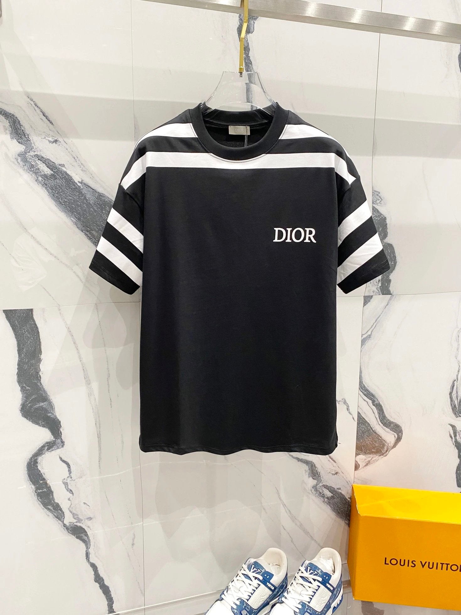 Black and white striped t-shirt with 'Dior' logo on a marble surface