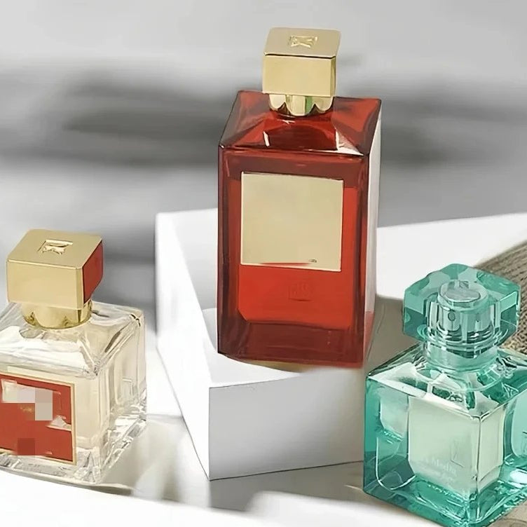 Three perfume bottles with different colored caps on a white surface.
