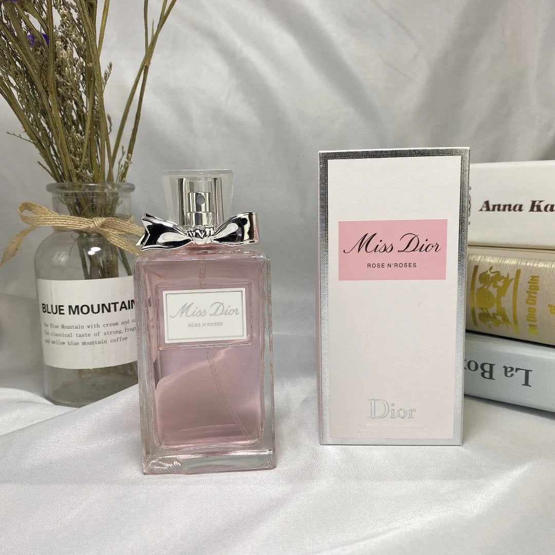 Miss Dior perfume bottle with packaging and a vase on a white surface