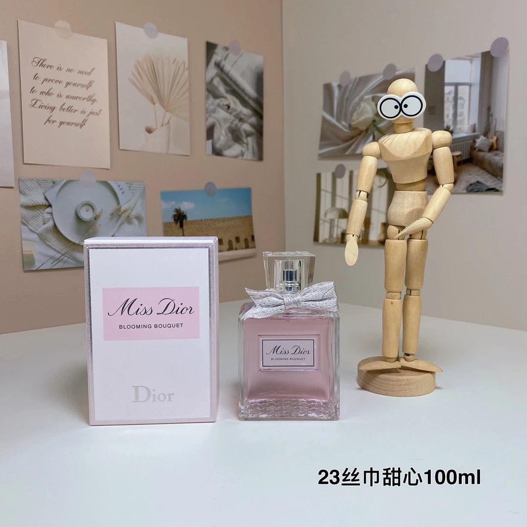 Miss Dior perfume bottle and packaging on a table with a wooden mannequin.