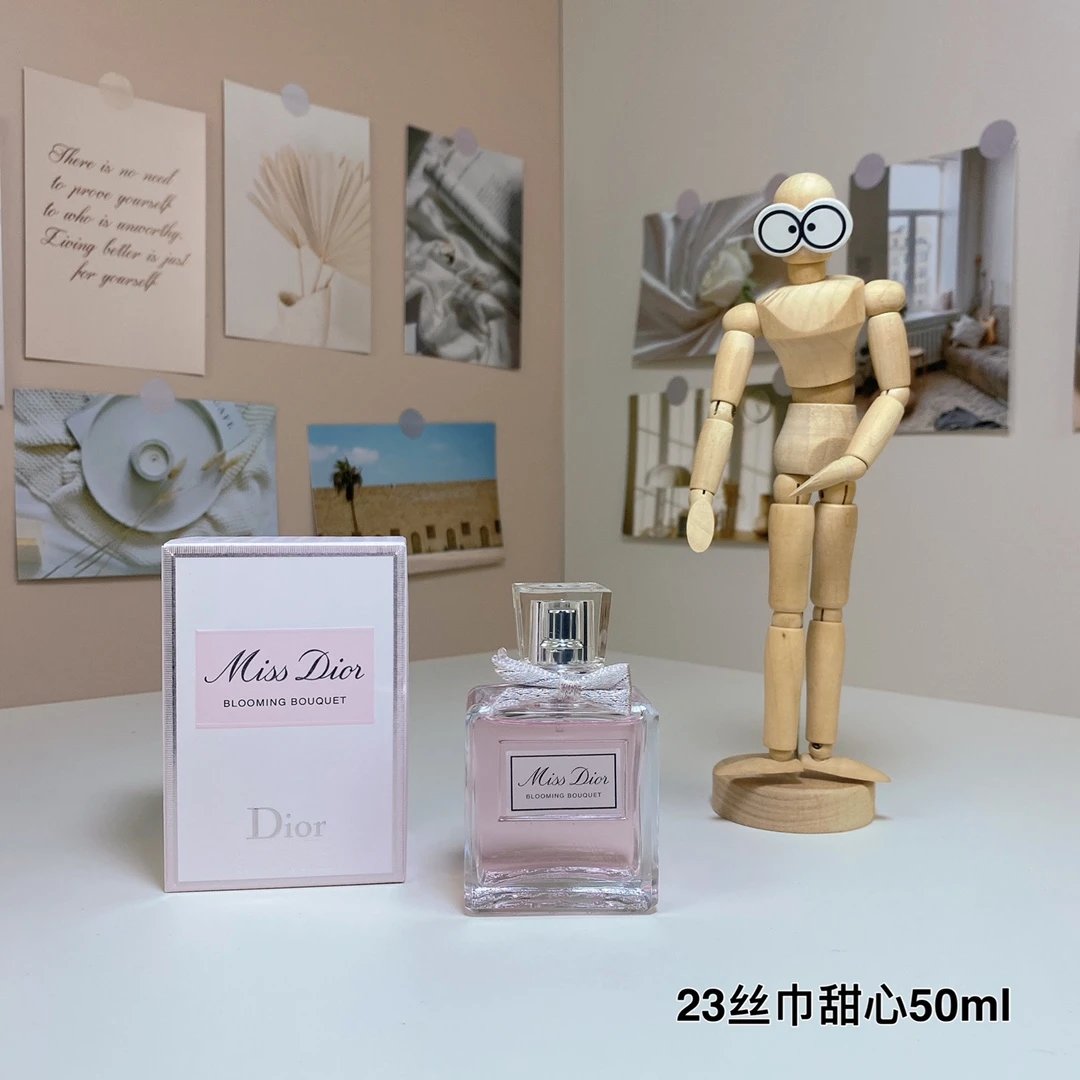 Miss Dior perfume bottle and packaging on a table with a wooden mannequin and decorative items in the background.