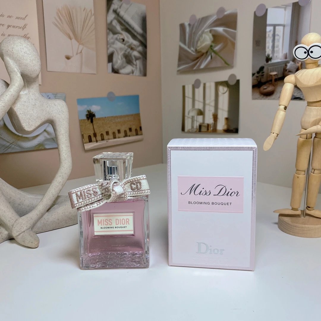 Miss Dior perfume bottle and packaging on a table with decorative items in the background.