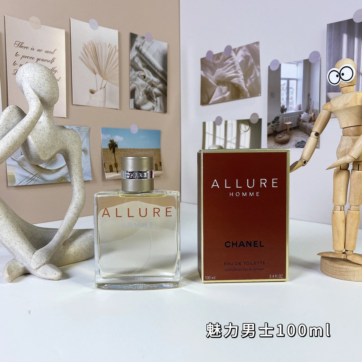 Chanel Allure perfume bottle and packaging on a white surface with decorative elements.