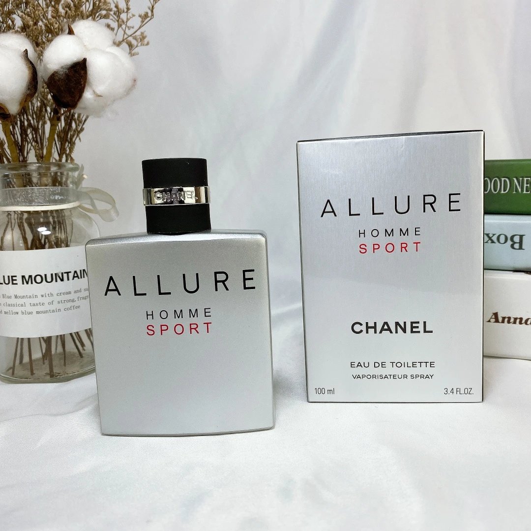 Chanel Allure Homme Sport perfume bottle and packaging on a white surface with cotton and a plant in the background.