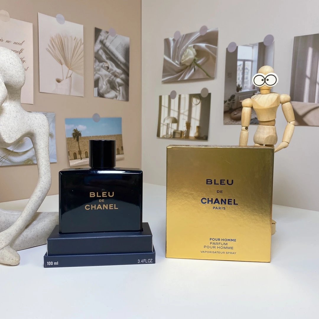 Bleu de Chanel perfume bottle and packaging on a table with decorative items in the background.