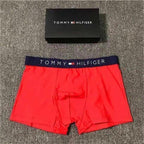 Red Tommy Hilfiger boxer briefs with a black box on a textured surface