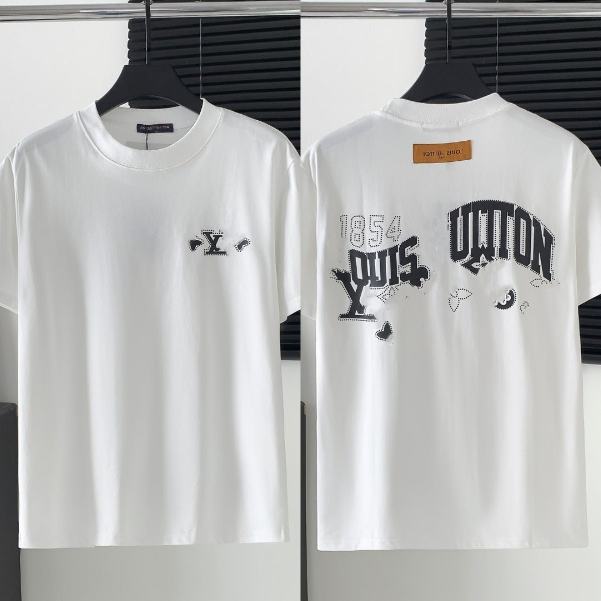 White t-shirt with black graphics and text on a hanger against a white background
